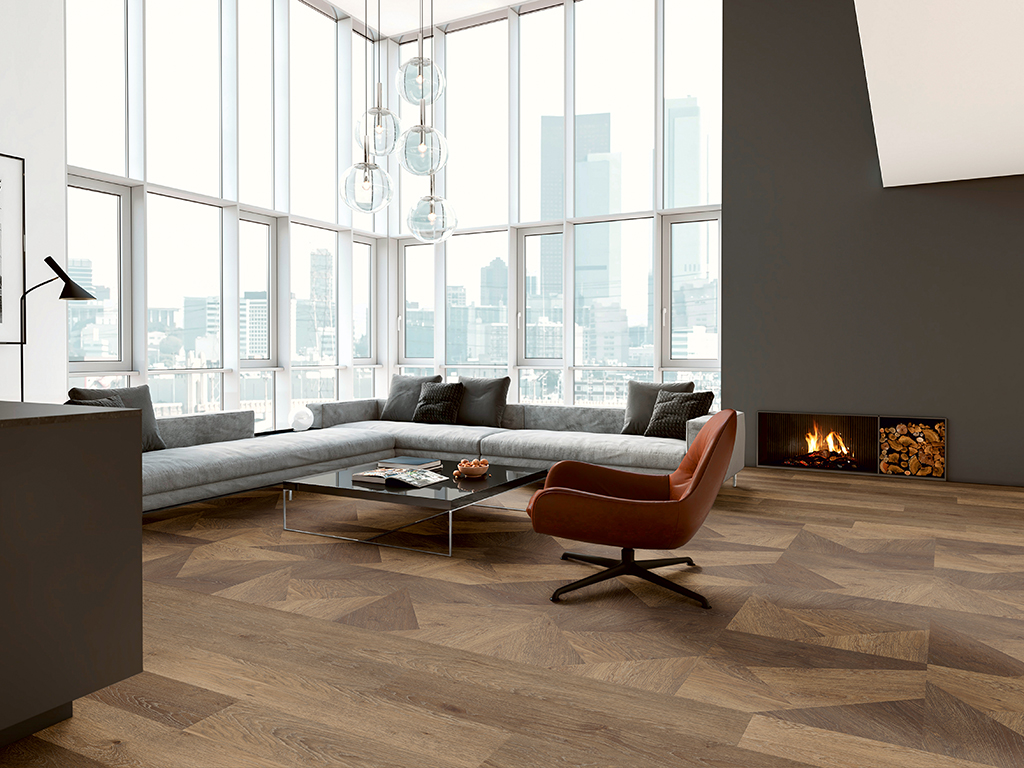 Modern hipster apartment interior. Open space loft, living room with dining room and kitchen in the back. Large white sofa, vintage decorative carpet, coffee table with coffee, seat, dining table with