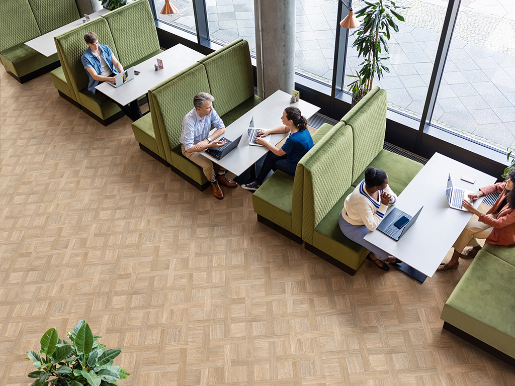 High angle view of a businessman and woman with laptops discussing work at a restaurant. People sitting at coworking office cafeteria.