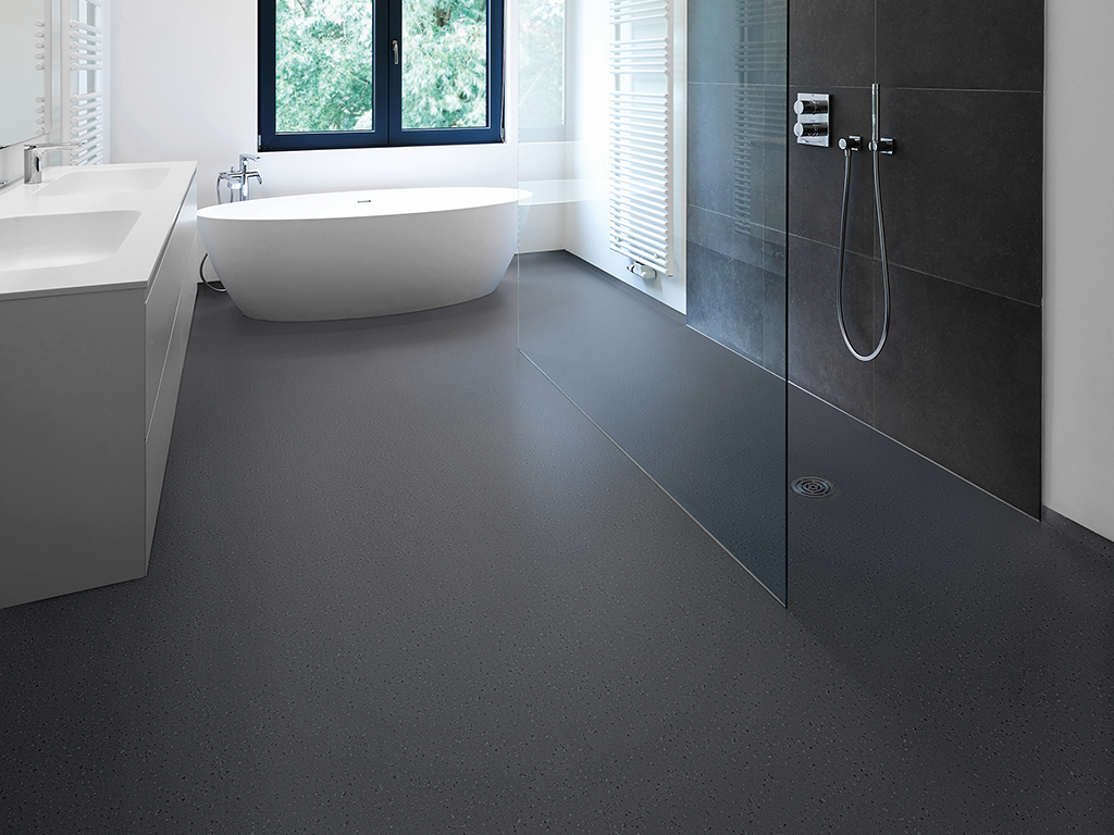 Bathtub in corian, Faucet and shower in tiled bathroom with windows towards garden